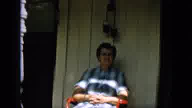 Pennsylvania (1957): Lady Sitting On Porch Waving Happily As People Pass By