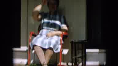 Pennsylvania-1957: Woman In Blue And White Dress Laughing And Gesticulating On Porch