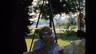 Pennsylvania (1957): Woman Eats And Wipes Mouth While Boy Waves And Balances On A