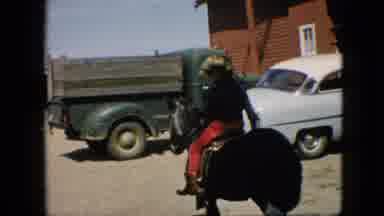 Pennsylvania (1957): Blond Child Rides A Pony In Front Of Vehicles.