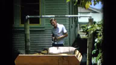 HAWAII-1965: Carpenter Man Crafting Homemade Wooden Boat Outside Home In Town
