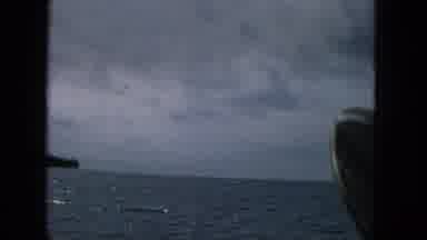 1965: Moody Ocean View From Boat Off Molokai Coast With Mountains And Overcast Sky