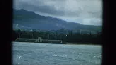 1965:EASTER MOLOKAI WHALES BEACH PARADE ALOHA TOWER. A Lake Overlooking A