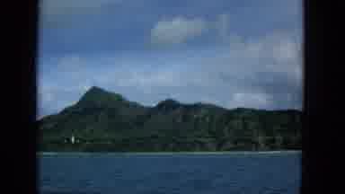 1965:EASTER MOLOKAI WHALES BEACH PARADE ALOHA TOWER. A Lake Overlooking A