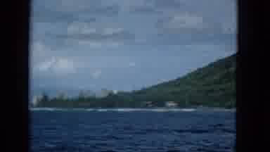 1965: Boat Ride Towards Molokai Island with Tropical Mountains and Coastal Buildings