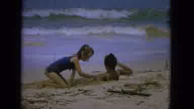 1965:EASTER MOLOKAI WHALES BEACH PARADE ALOHA TOWER. Little Girl Burying Her