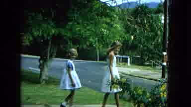 1965: Young Girls in White Dresses Walking Suburban Hawaii Street