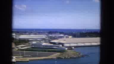 1965: Aerial View of Honolulu with Diamond Head, Coastal Cityscape, and Light Traffic