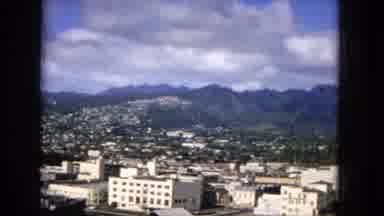 1965:EASTER MOLOKAI WHALES BEACH PARADE ALOHA TOWER. Pan Of A City Skyline