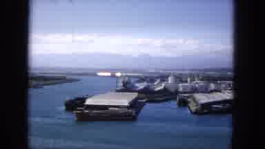 1965: Panned Aerial View Of Molokai Harbor With Industrial Docks And Mountains