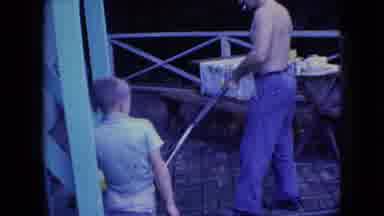 Wellsburg Iowa (1965): Father Brings Out Lawn Mower While Son And Animal Watches