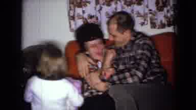 Wellsburg Iowa (1965): Two Adults Kissing And Child Holding A Bear.