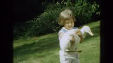 Wellsburg Iowa (1965): Little Young Child Laughing And Having Fun After Holding A