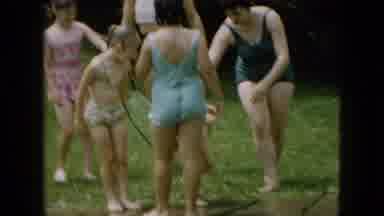 Wellsburg Iowa (1965): Women And Girls In Swimwear Gather In Yard With Garden Hose