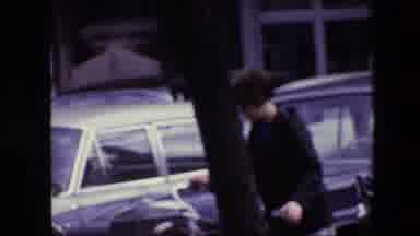 Amsterdam Netherlands (1967): Bicyclists Cross A Wide Street In Front Of Stopped
