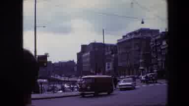 Amsterdam Netherlands (1967): People And Vehicles Use A Busy Urban Street That