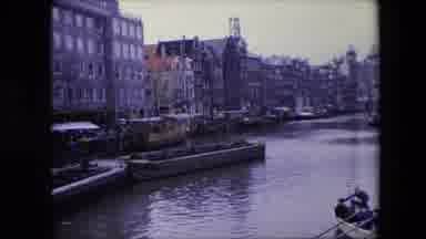 AMSTERDAM NETHERLANDS-1967: Tall Buildings Lining A Waterway In What Appears To