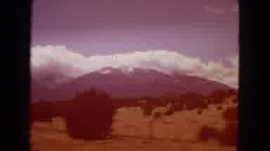 Arizona (1967): A Car Driving Down The Road Of A Wide Open Landscape.