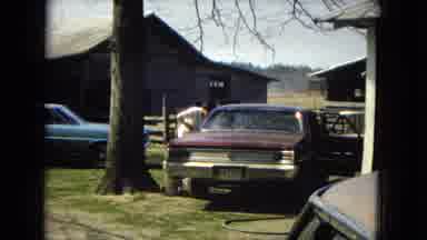 ARIZONA-1967: Man Vacuums Red Classic Car Near Tree In Front Of Barn