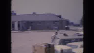 Iowa USA (1967): A Woman Watches Three Children Play With A Dog Near A Parking Lot