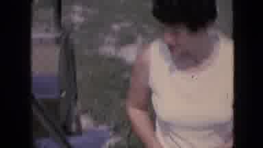 Iowa USA (1967): Woman Is Handed Items From A Car Then Turns To Look At The Camera