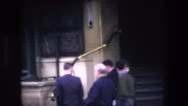 London England (1967): Guys Walking Past Metal And Brick