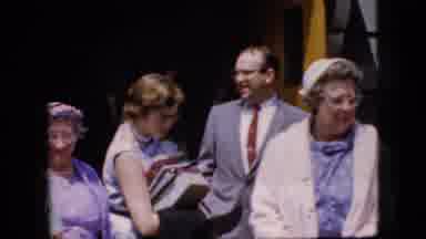 California USA (1969): Lady With Books Walks Away From Group