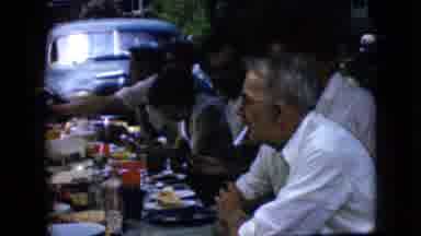 California USA (1969): Group Of Older People Eating Together At A Picnic Table
