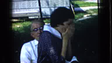 California USA (1969): Girl Sitting On A Man's Lap While She Coughs Into Her Hand