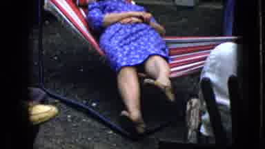 California USA (1969): Woman Relaxing In A Hammock In A Yard While Rocking Back
