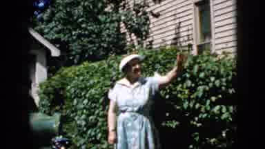 California USA (1969): Older Lady Waving Friendly In Front Of The Bush