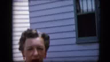 California USA (1969): A Mature Woman Talks In Front Of The Outside Wall Of A