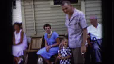 California USA (1969): Mother Holding Baby Father Standing With Son People Sitting