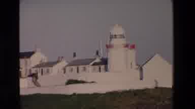 Ireland (1969): Whitewashed Buildings By The Water Including A Lighthouse