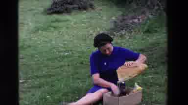 Loudes France (1969): Mother Opening Up Package Of Bread For Picnic
