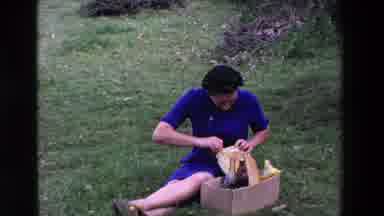 Loudes France (1969): Middle Aged Woman Sitting In The Grass With A Picnic Basket
