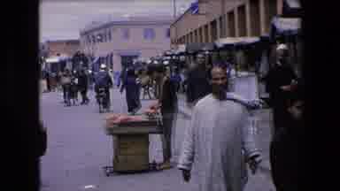 Algeria (1971): People Walking On A Street Past Market Stalls