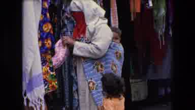 Algeria (1971): Woman Inspecting Cloth Goods Busy Outdoor Marketplace