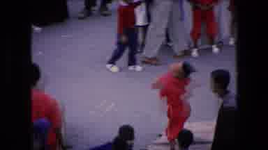 ALGERIA-1971: Children In Red Uniforms Perform Acrobatic Flips And Handstands On Street