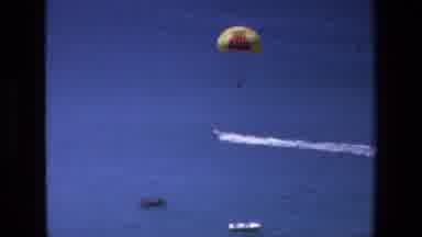 Mazatlan Mexico (1972): A Boat Speeds Across Blue Water Pulling A Parasail Behind