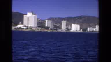 Mazatlan Mexico (1972): A Boat Sailing Alongside The Shoreline Of A City
