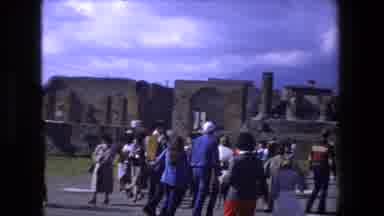 ROME ITALY-1973: Tourists Explore Ancient Roman Ruins with Brick Structures and Classical Columns