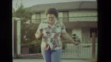 Malibu California USA (1981): Woman Running In Front Of Desert Home With Wall
