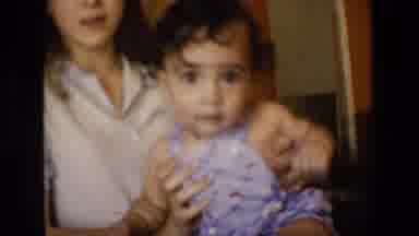 San Antonio Texas-1982: Young Woman Holding Baby in Home Setting