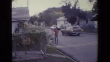 San Antonio Texas (1982): Waving Man, Carrying Baby With Elderly Woman Near Busy
