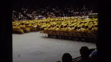 Lansing Michigan (1983): Graduates In Cap And Gown Sit In Front Of A Stage While