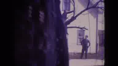 PHILADELPHIA PENNSYLVANIA USA-1964: Man Trimming Tree Near Large House