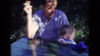 New Jersey USA (1965): Man Smoking Cigarette Little Boy Outside On Picnic Table