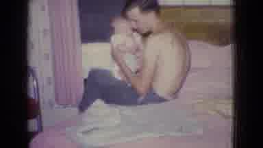 New Jersey USA (1965): Man With Infant Child On Bed Showing Boat On Water