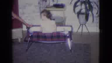 New Jersey USA (1965): Baby In Bassinet With Older Child Holding On Playing In